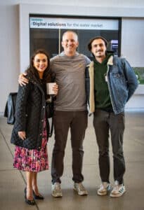 One woman and two men posing for a photo together.